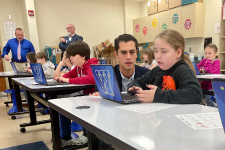 Representative Dani Isaacsohn works with a Belle Aire Intermediate School student on their laptop